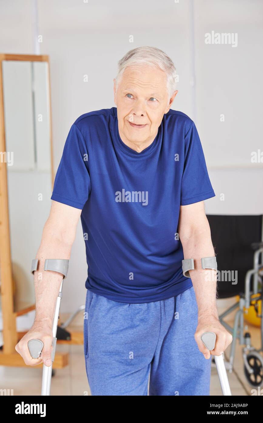 Uomo vecchio con le stampelle riabilitazione imparare a camminare di nuovo Foto Stock