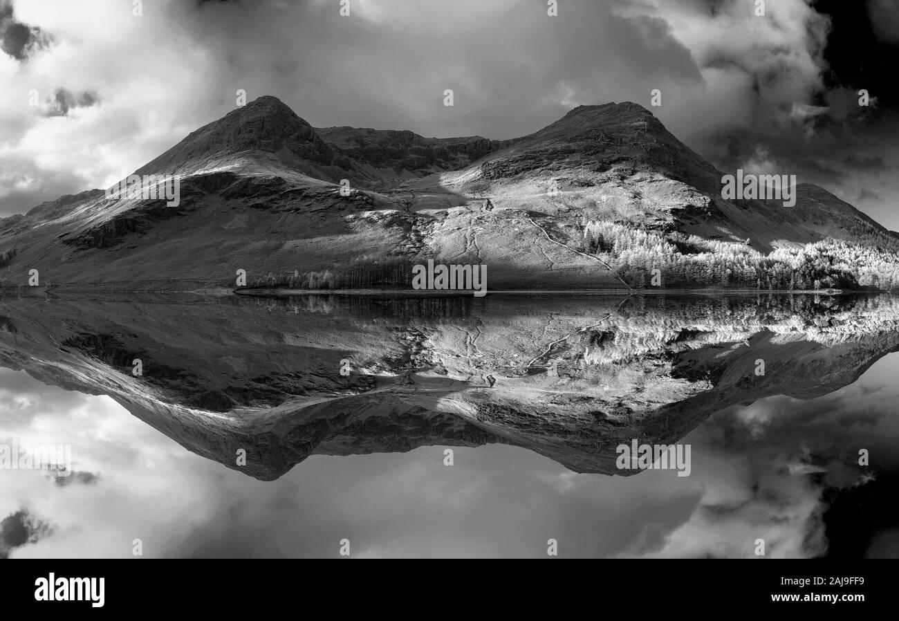 Incredibile epic Autumn Fall paesaggio Buttermere nel Lake District con una bella mattina presto la luce del sole giocando attraverso le colline e le montagne Foto Stock