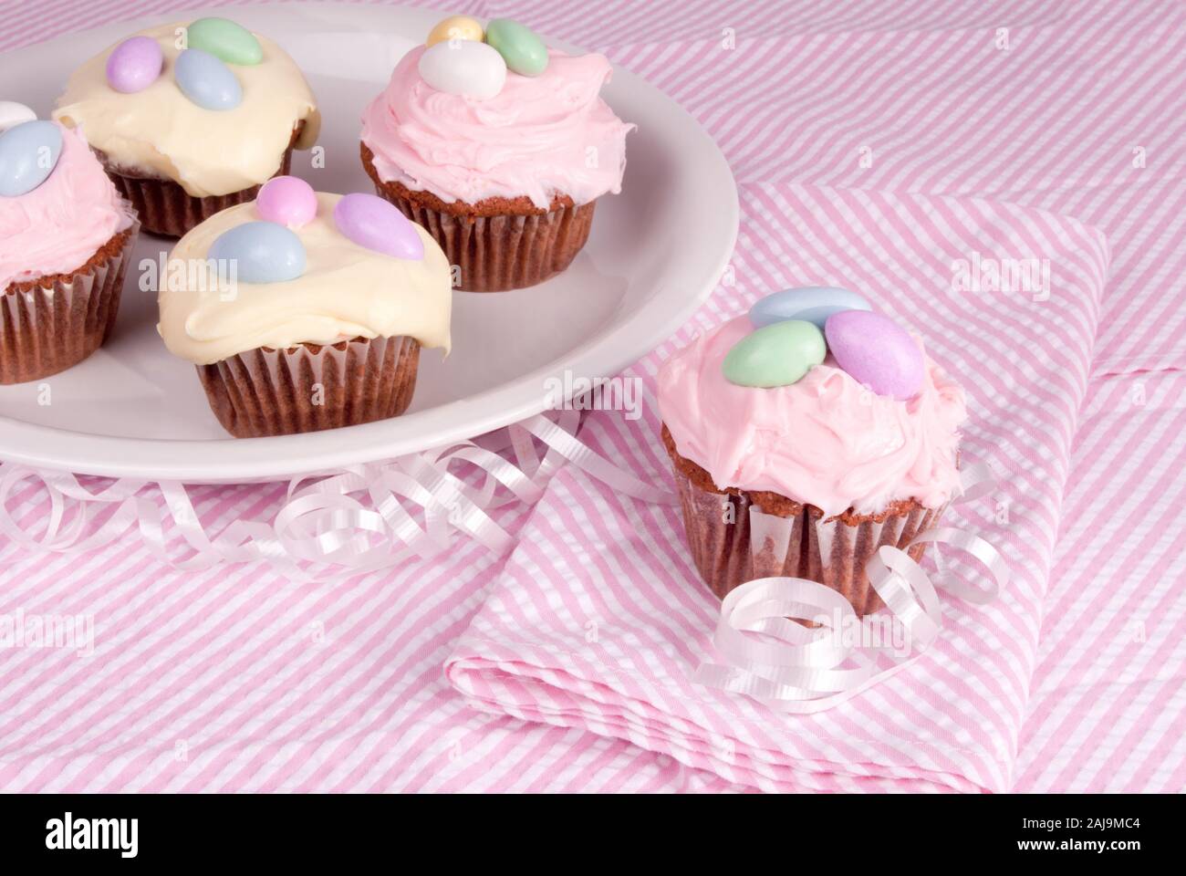 In casa Red Velvet tortine guarnita con crema di burro color pastello la glassa. Disco a forma di uovo di caramelle sono sulla parte superiore. Foto Stock