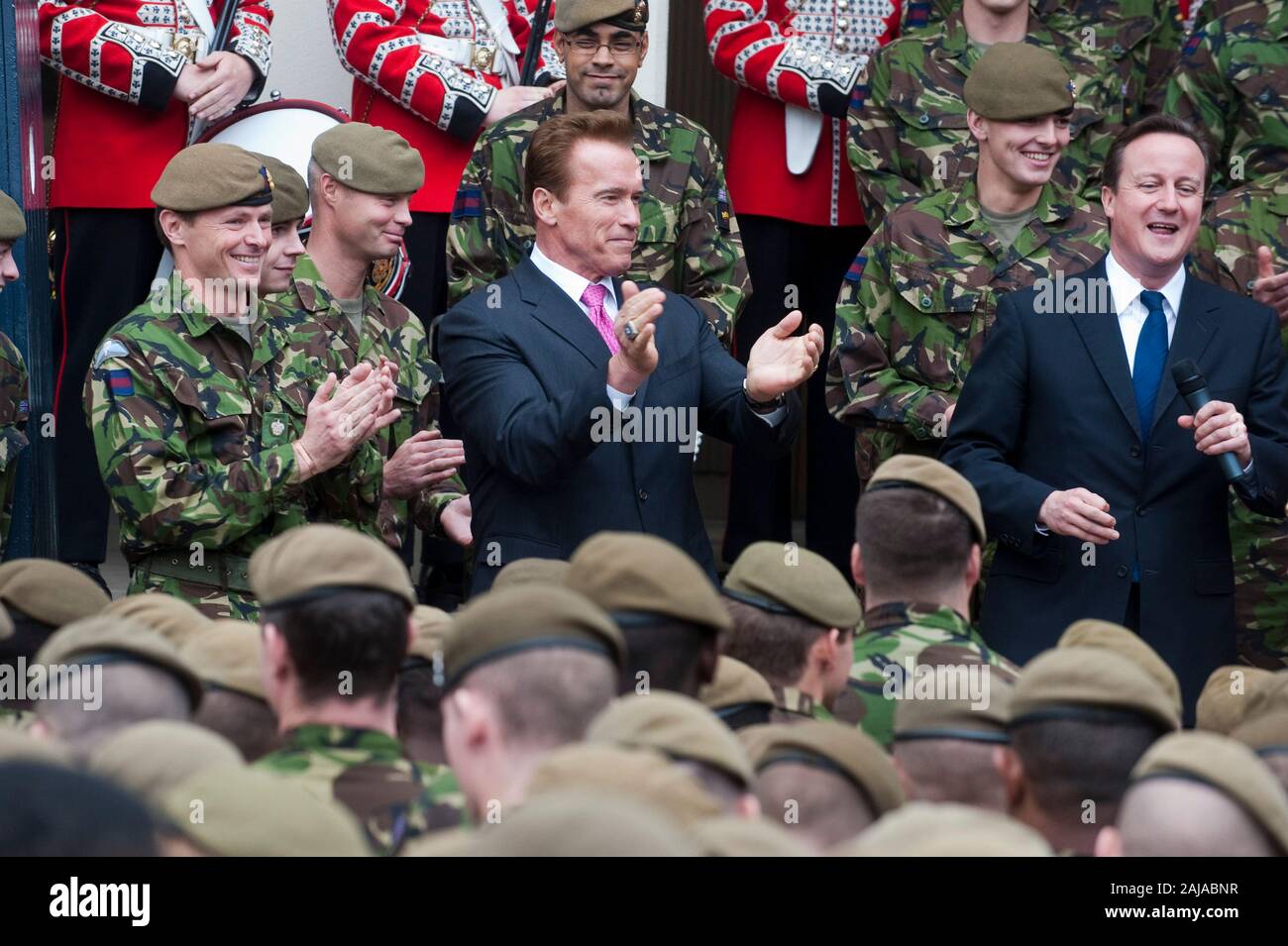 Il governatore della California Arnold Schwarzenegger e il Primo Ministro David Cameron con le truppe britanniche dal primo battaglione di guardie granatieri presso la caserma di Wellington a Londra. Foto Stock