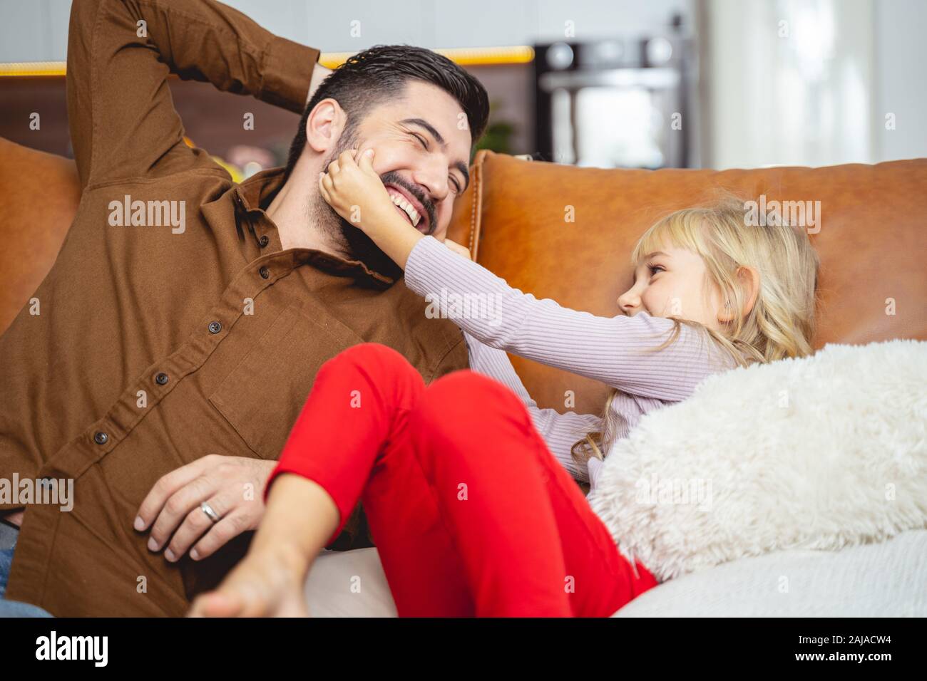 Carina bambina che si diverte con il suo papà a casa Foto Stock