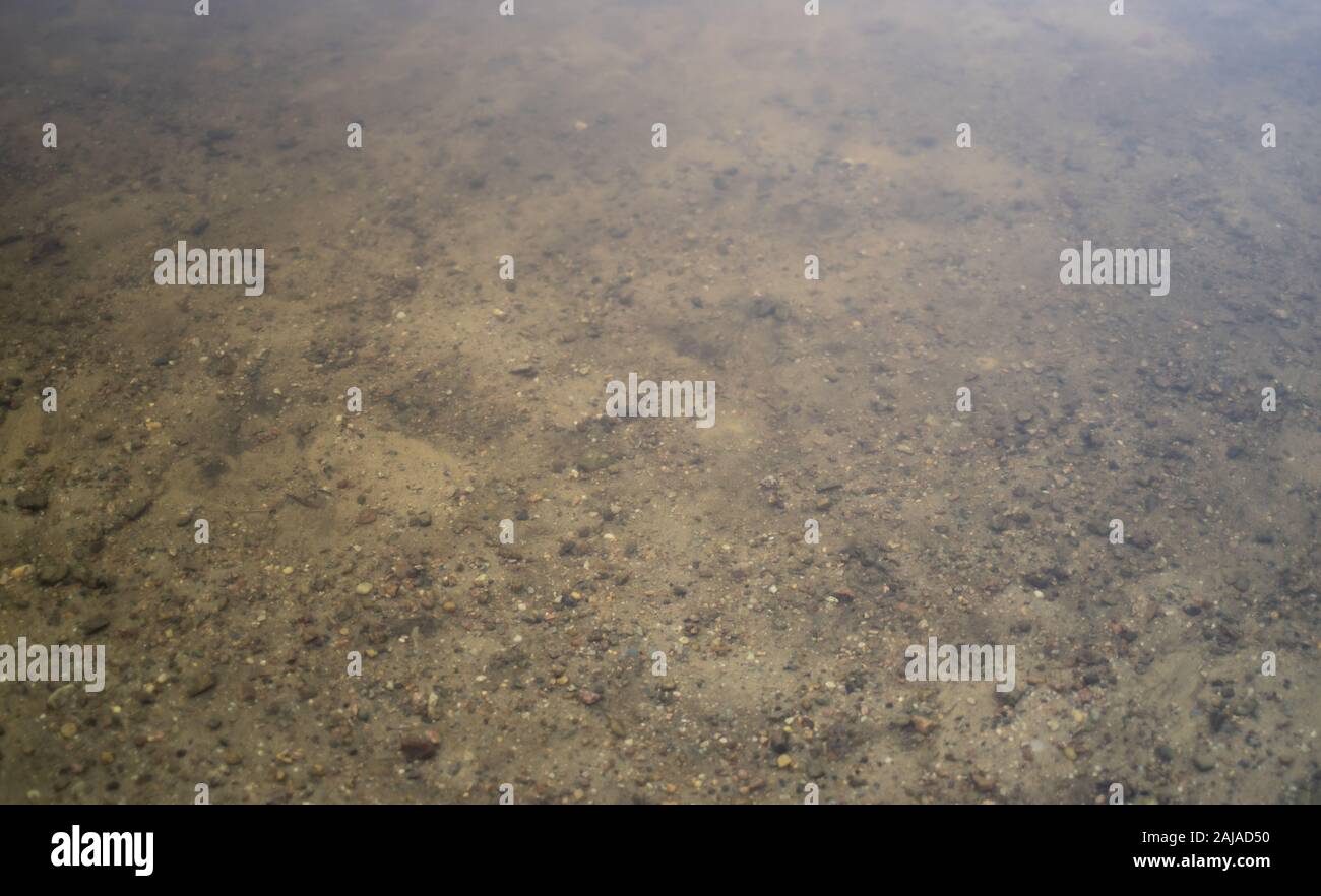 Sullo sfondo di un alveo fluviale attraverso la superficie dell'acqua Foto Stock