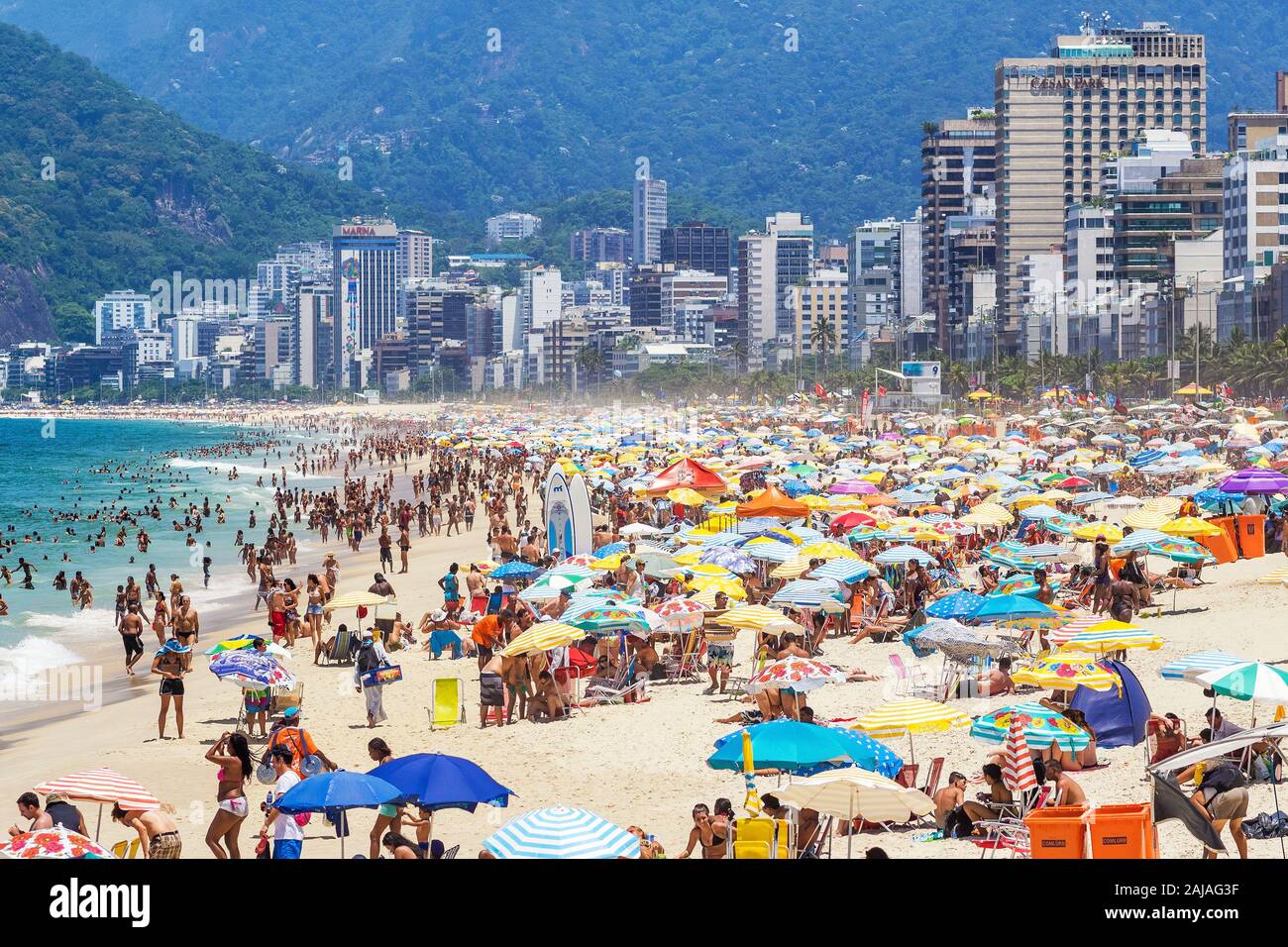 I turisti e i locali godendo l'estate alla famosa spiaggia di Ipanema a Rio de Janeiro in Brasile. Foto Stock