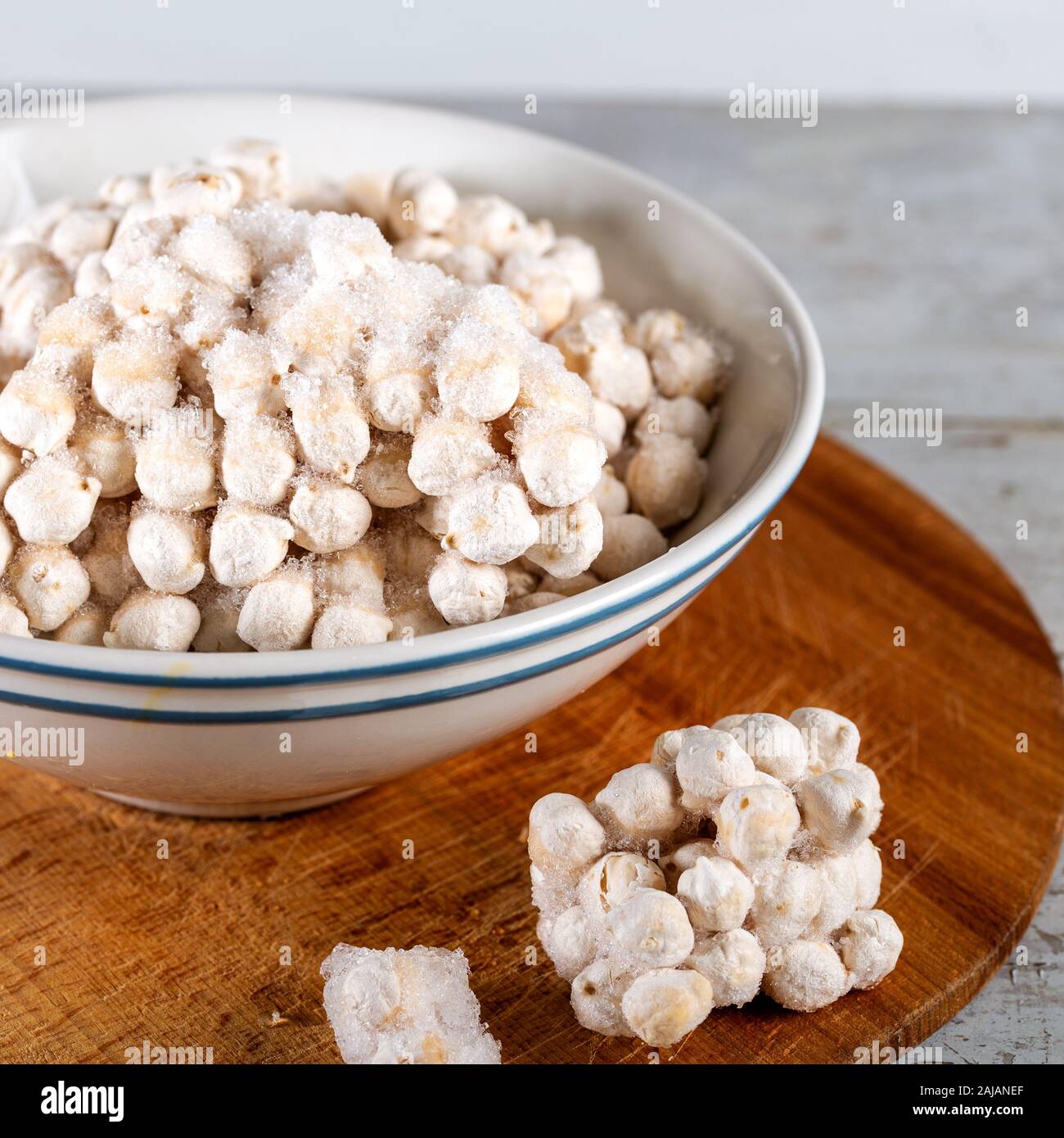 Ceci surgelati in ciotola su fondo di legno. Foto Stock