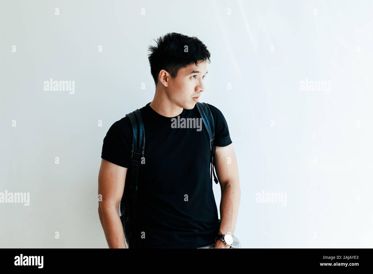 Giovane bello ragazzo asiatico vestita di nero plain shirt e zainetto al giorno in Sai Gon city, Vietnam - uno stile di vita informale di adolescente vietnamita Foto Stock