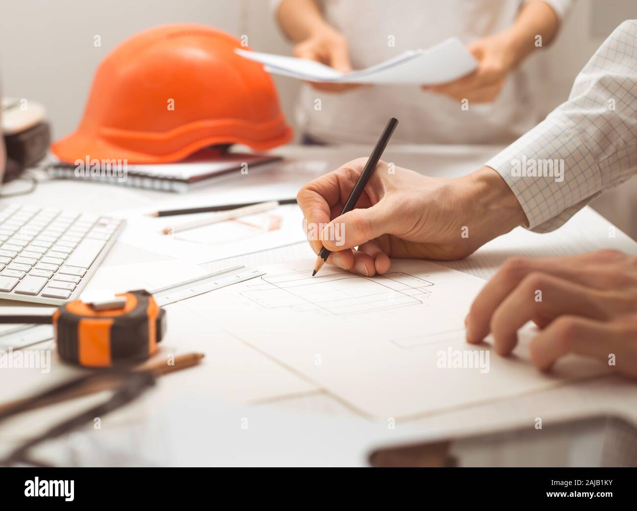 Un team di architetti sviluppa un disegno per progetti di costruzione. Gli ingegneri creano uno schizzo sul posto di lavoro. Concetto di costruzione. Foto Stock