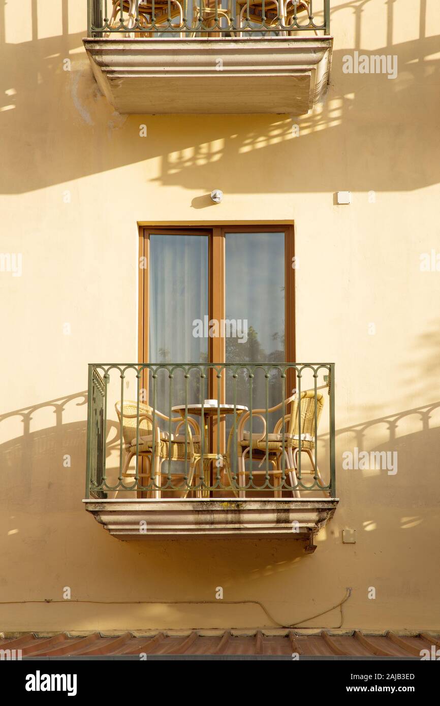 Tavolo e sedie su una piccola finestra balcone su un edificio a Sorrento Italia Foto Stock