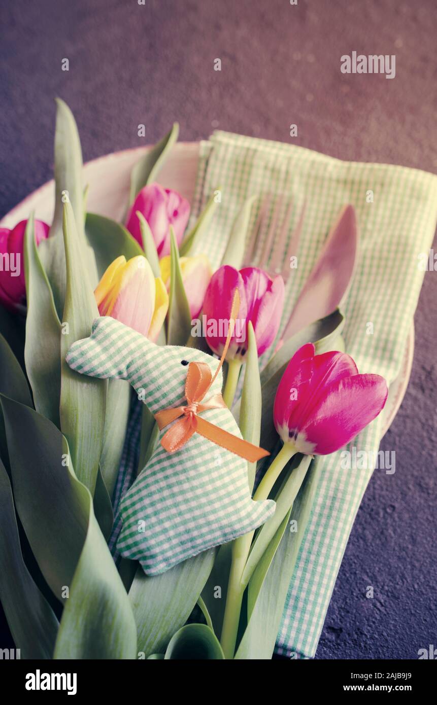 Pasqua messa in tavola con bouquet di tulipani e posate. Preparazione per la festosa cena di Pasqua. Vista dall'alto. Foto Stock