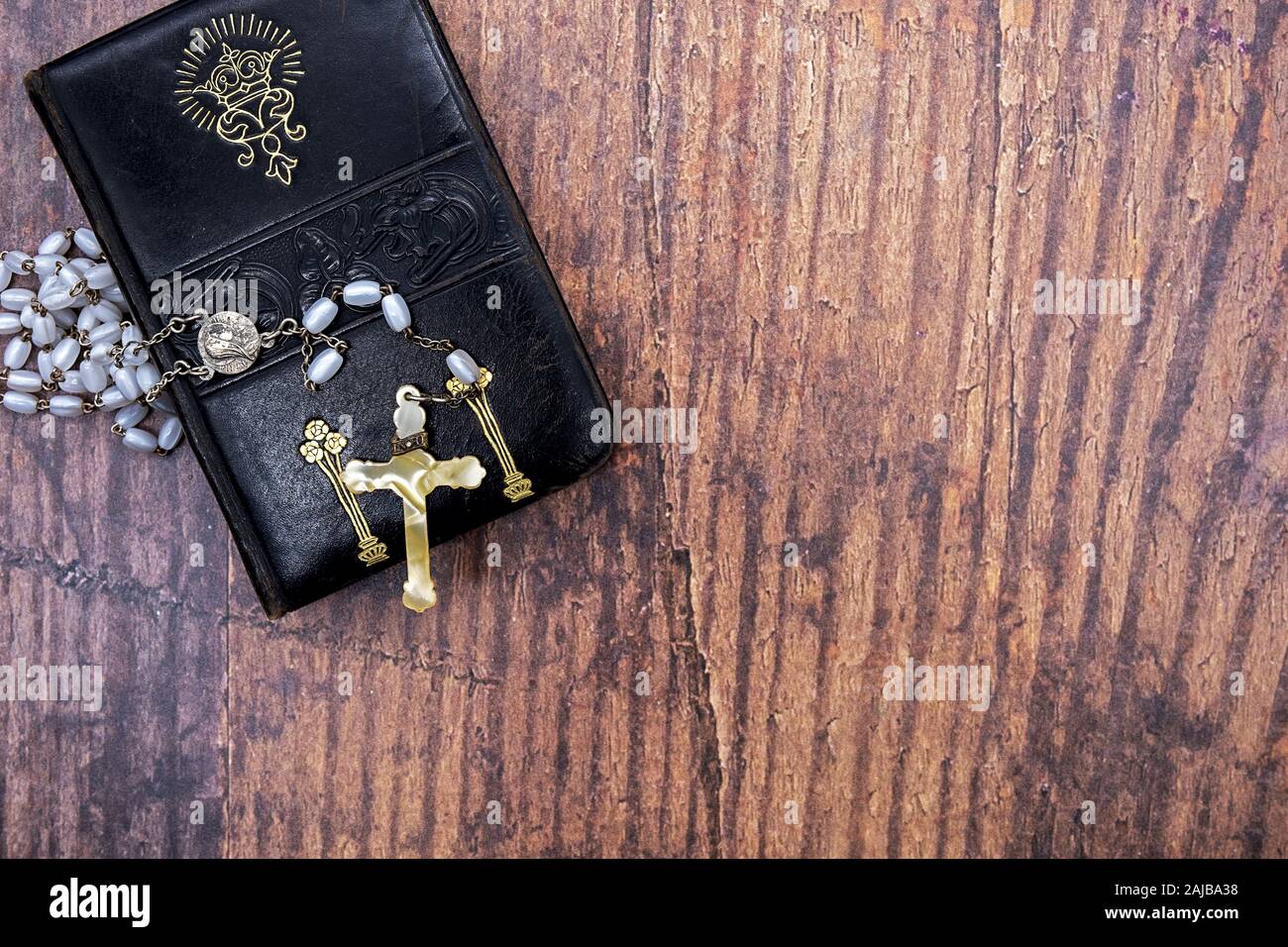 Vecchia pelle-bound libro di preghiera con l oro di goffratura e art nouveau motivo floreale e vecchio rosario con croce in avorio Foto Stock