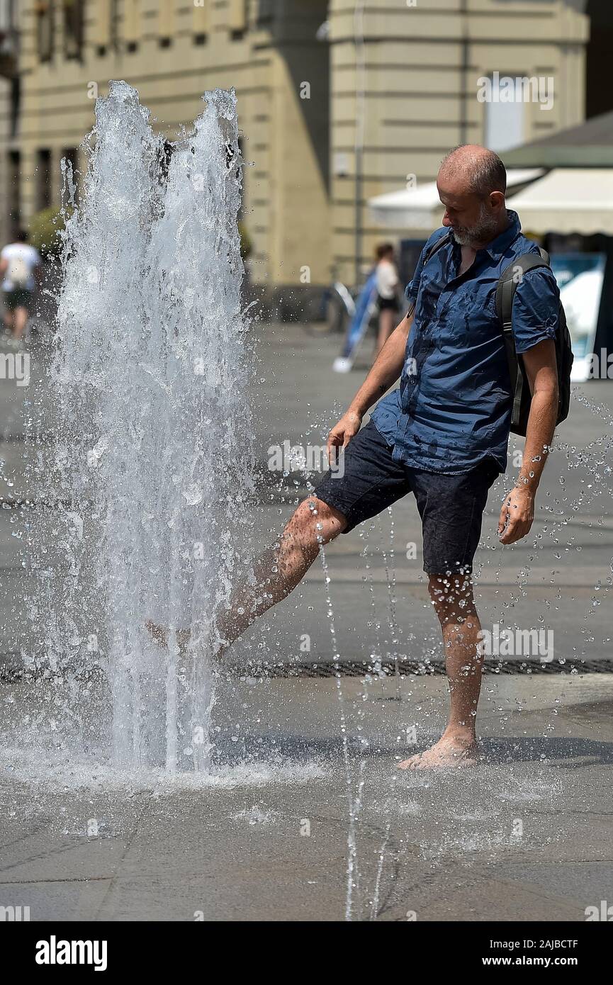 Torino, Italia - 24 July, 2019: un uomo aggiorna se stesso con l'acqua di una fontana pubblica. Un eccessivo riscaldamento spia è stato designato in 13 città italiane. Credito: Nicolò Campo/Alamy Live News Foto Stock