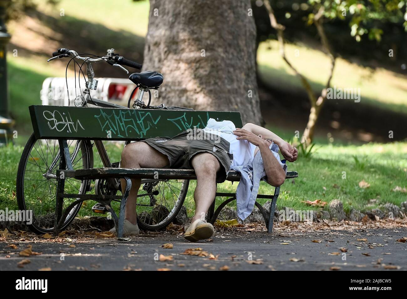 Torino, Italia - 24 July, 2019: Un vecchio uomo dorme in ombra sotto un albero. Un eccessivo riscaldamento spia è stato designato in 13 città italiane. Credito: Nicolò Campo/Alamy Live News Foto Stock