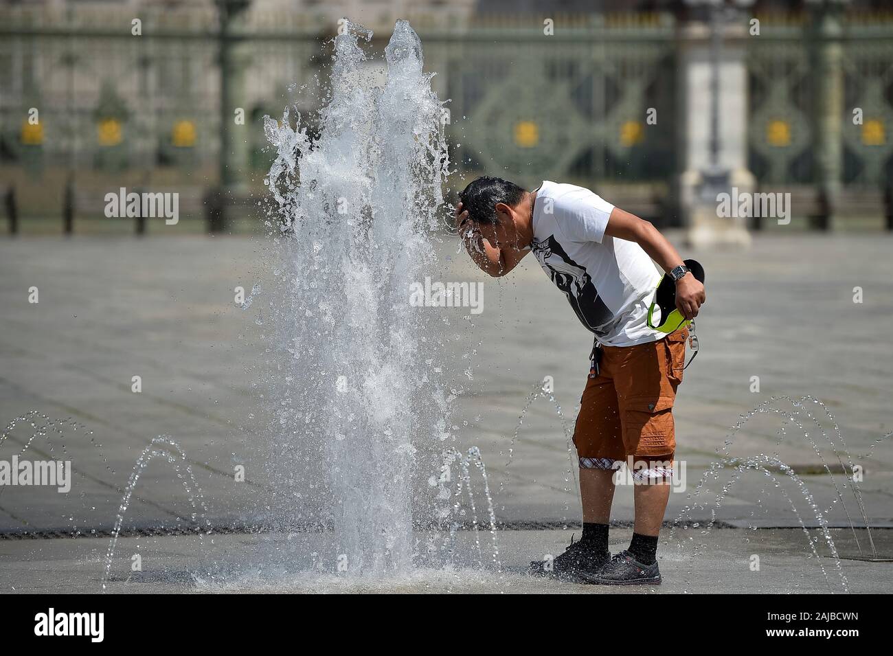 Torino, Italia - 24 July, 2019: un uomo aggiorna se stesso con l'acqua di una fontana pubblica. Un eccessivo riscaldamento spia è stato designato in 13 città italiane. Credito: Nicolò Campo/Alamy Live News Foto Stock