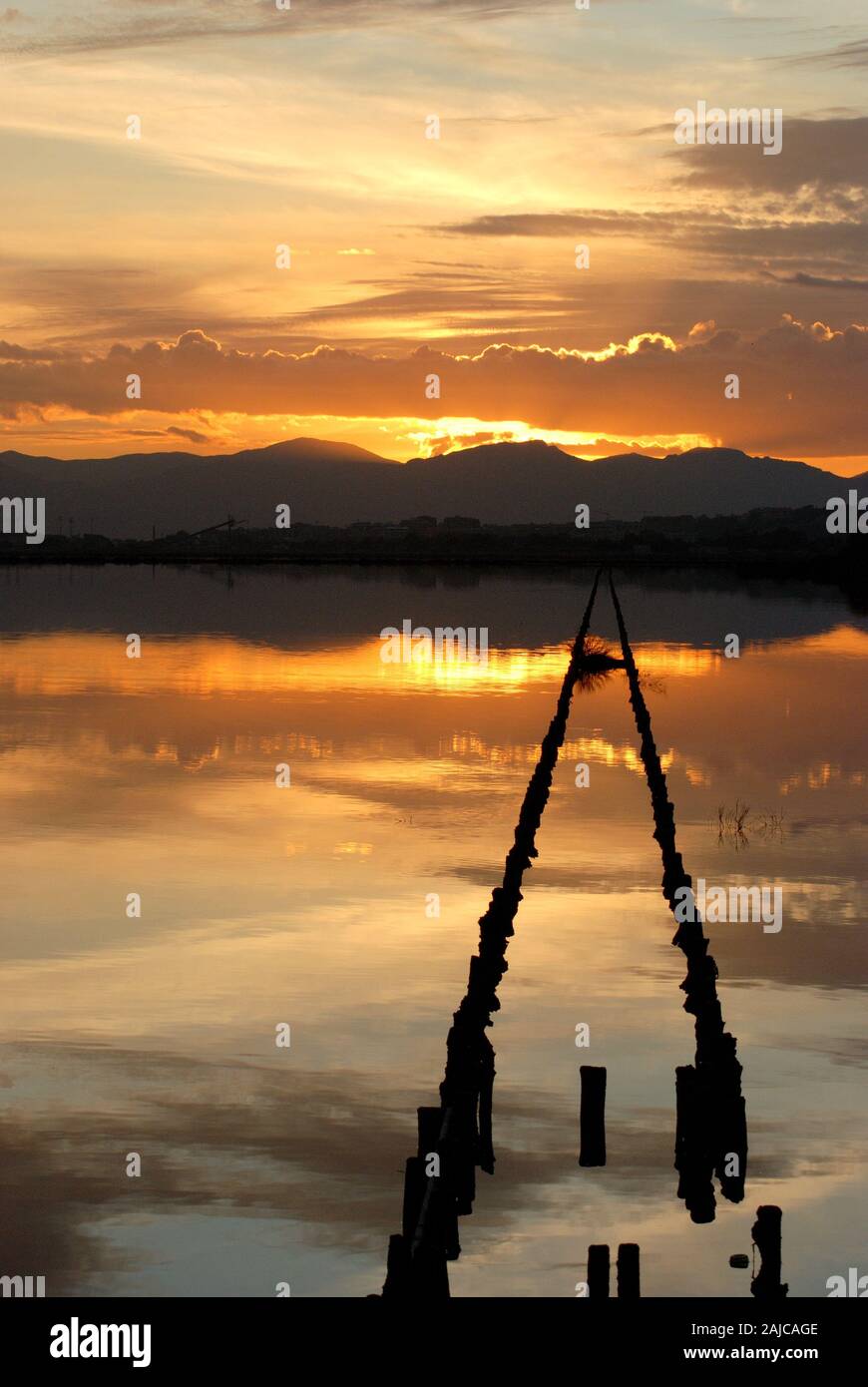 Tramonto sulla soluzione salina nel parco di Molentargius Cagliari Italia, oro nuvole si riflettono nell'acqua. Foto Stock