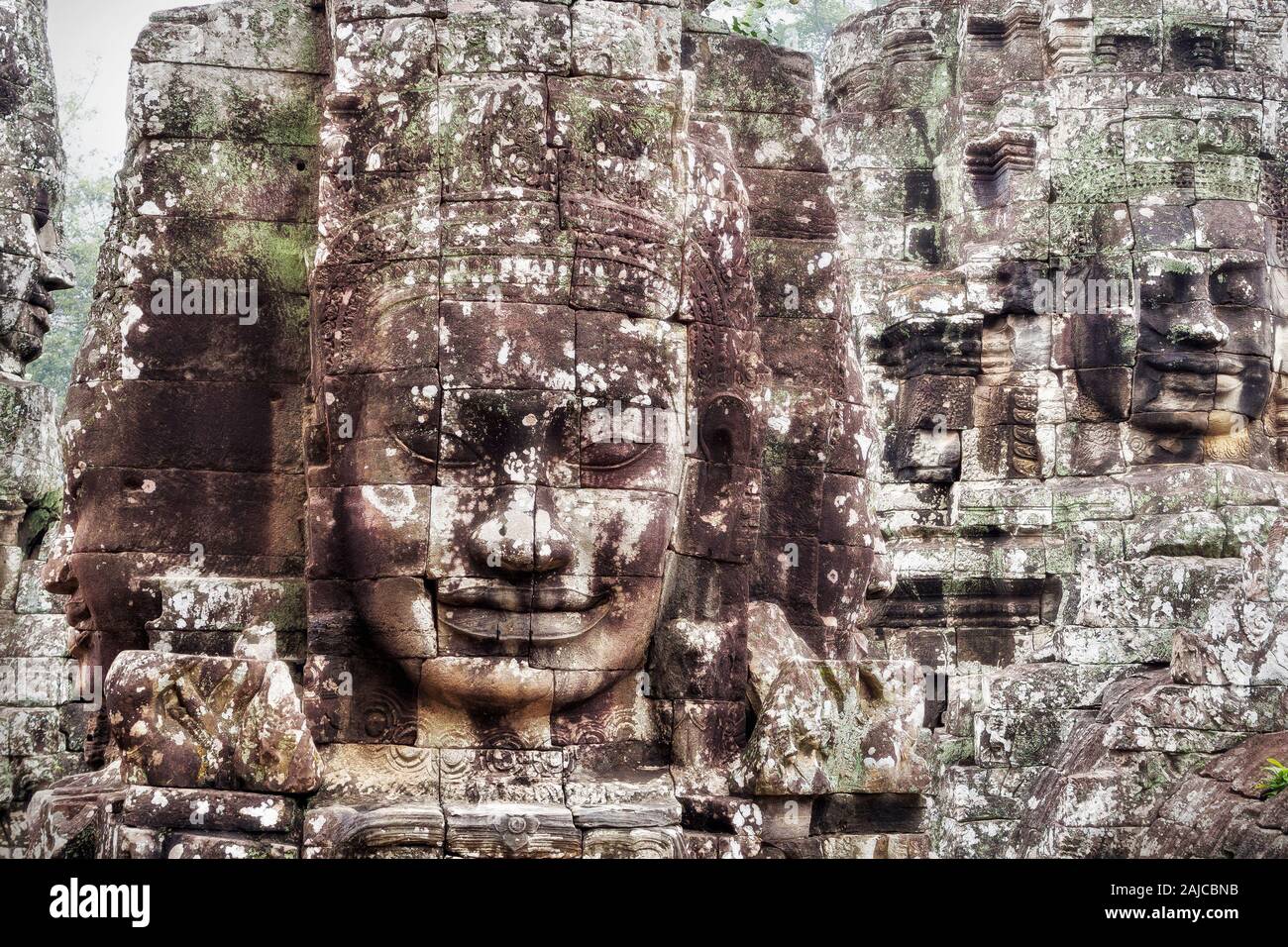 Gigante di pietra si affaccia l'antico tempio Bayon ad Angkor, Siem Reap, Cambogia. Foto Stock