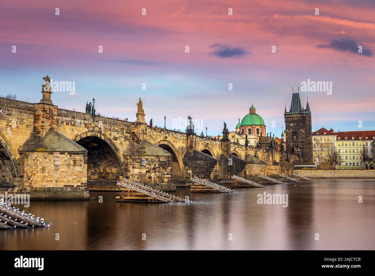 Praga, Repubblica Ceca - il famoso Ponte Carlo (Karluv most) con un bel cielo viola e del tramonto su un pomeriggio invernale Foto Stock