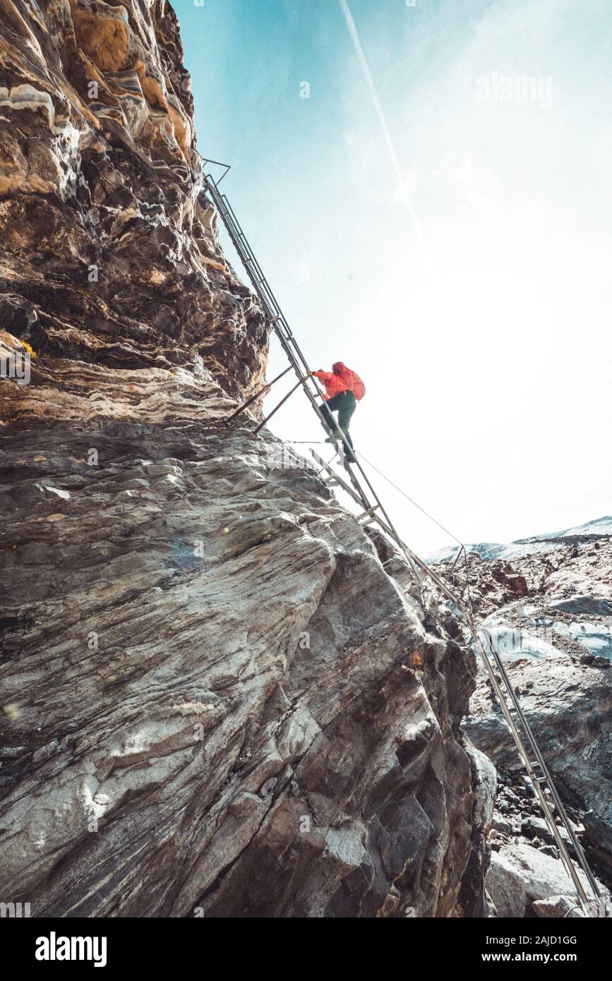 Donna che scende giù per la scala del ghiacciaio in Svizzera Foto Stock