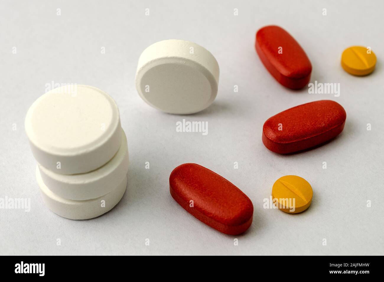 Diversi tipi di pillole o compresse, forse le sostanze stupefacenti, antibiotico o aspirina, su sfondo chiaro. Medicina e Farmacia concetto. Non isolata. Close-up. Foto Stock