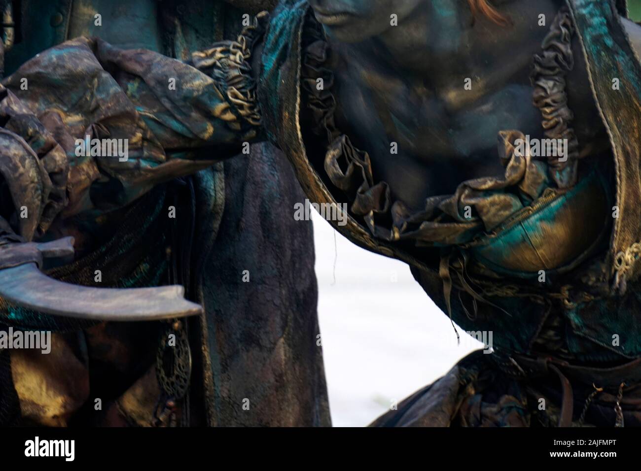 Dettagli della statua vivente di due pirati. Donna e uomo vestito in costumi di bronzo con cappelli e le armi costituiscono come una realistica statua umana.Close up shot Foto Stock