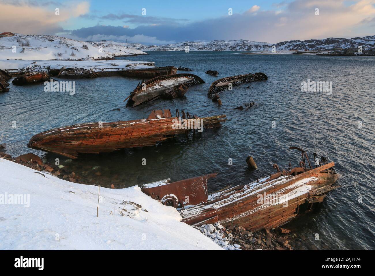 Cimitero di piccole barche da pesca in Teriberke al tramonto. La regione di Murmansk, Russia Foto Stock