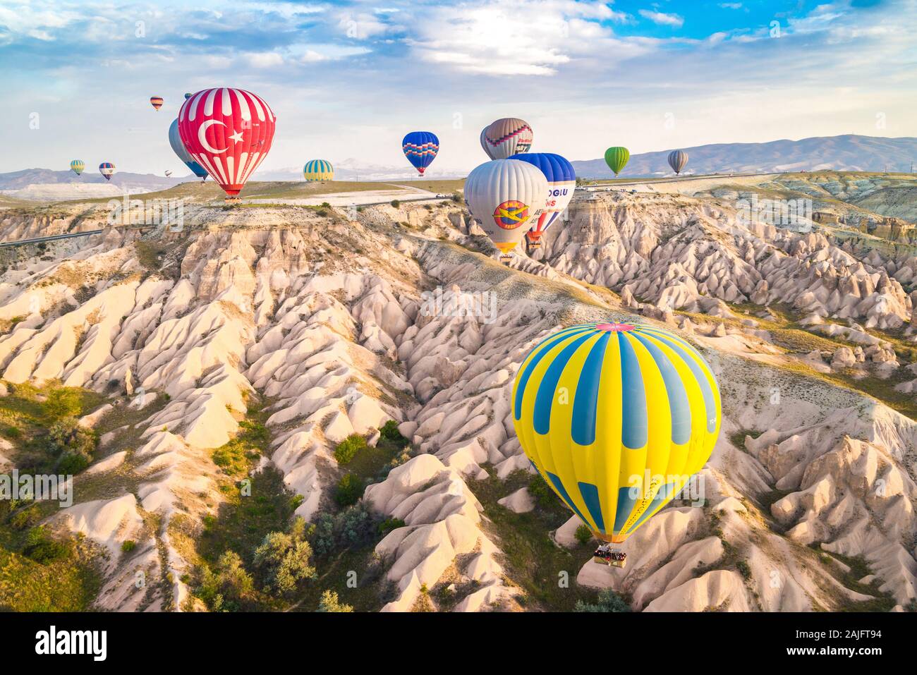 I palloni ad aria calda volando sul paesaggio surreale di Camini di Fata in Cappadocia, Goreme, Turchia Foto Stock