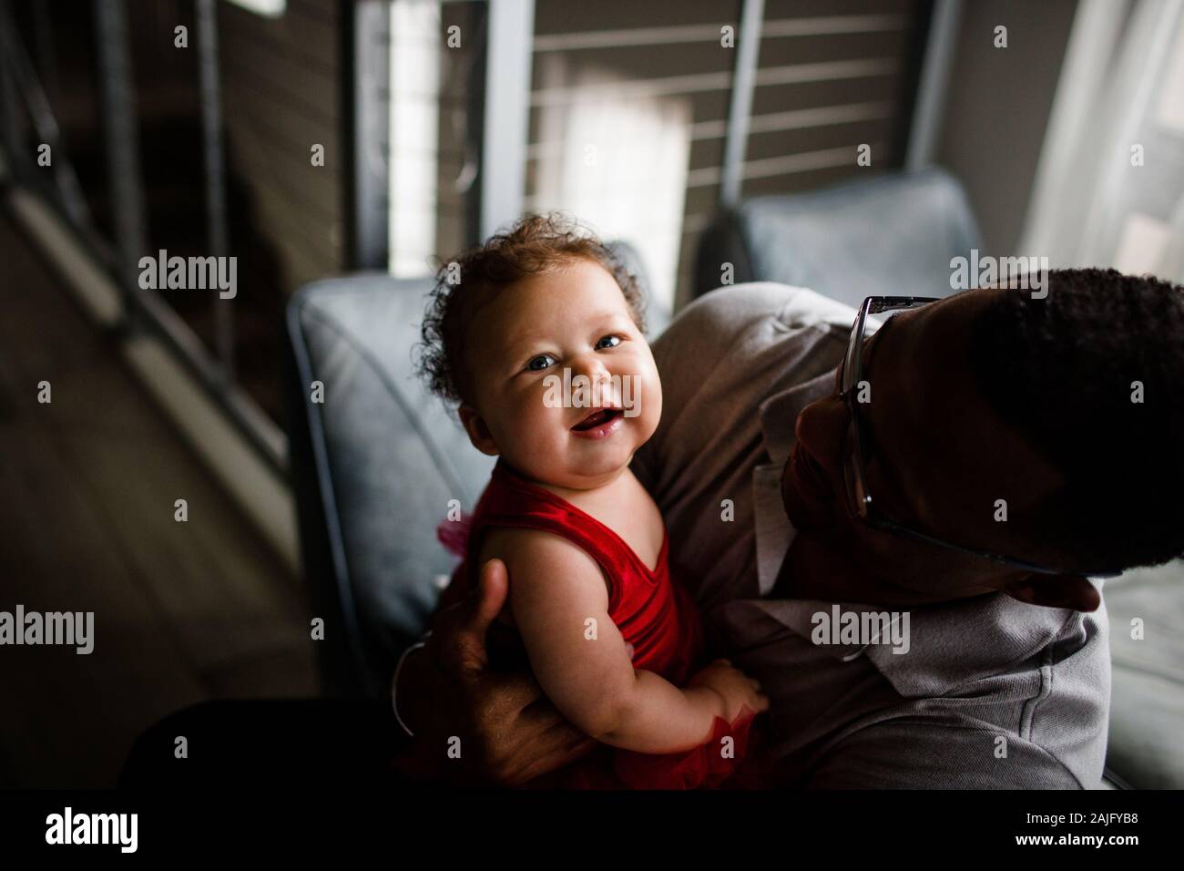 Biracial Baby sorridente per Camera come African American papà sorride Foto Stock