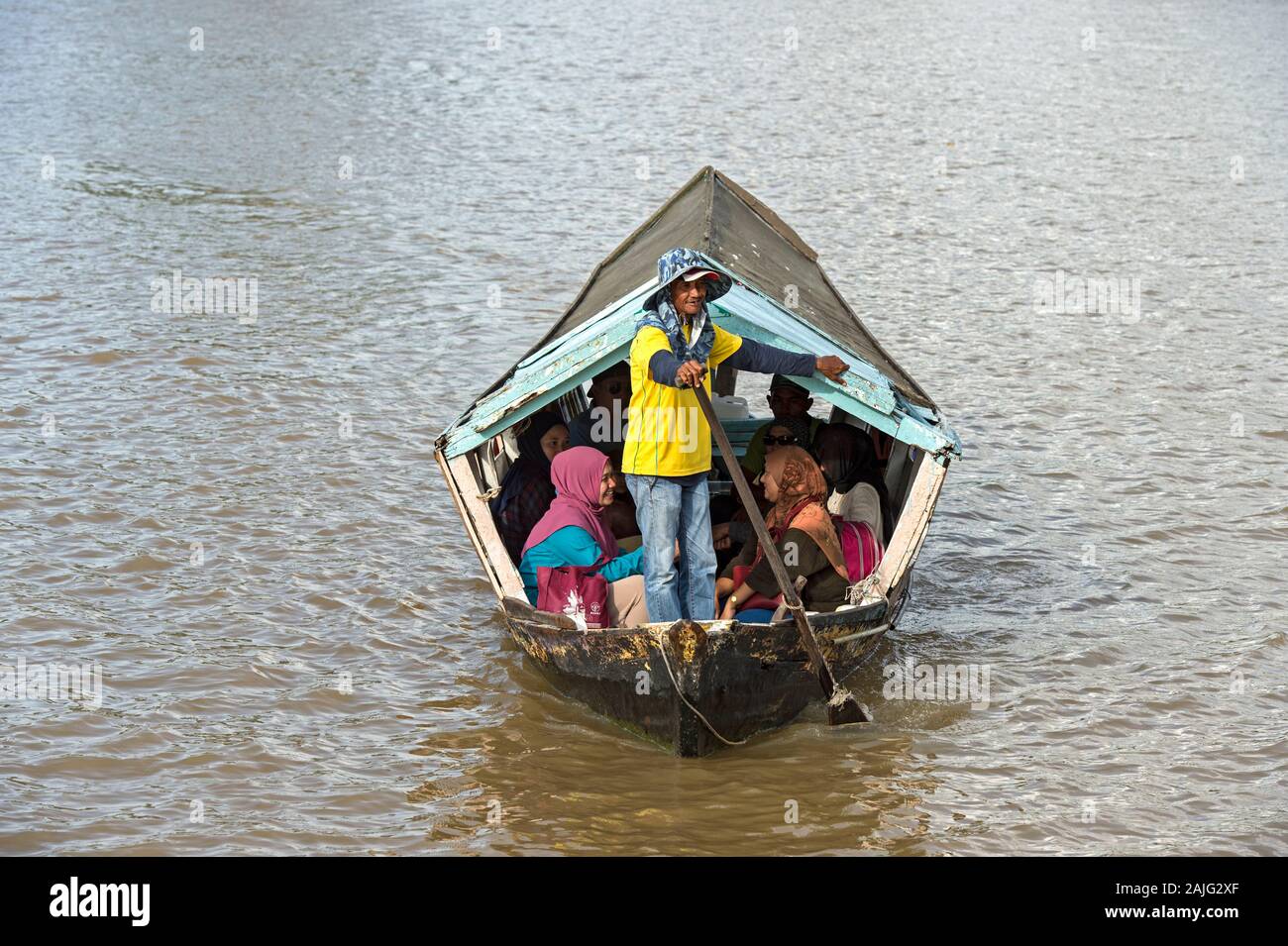 Sampan l uomo nel suo traghetto, chiamato tambang, sul fiume Sarawak Kuching, Sarawak, Borneo, Malaysia Foto Stock