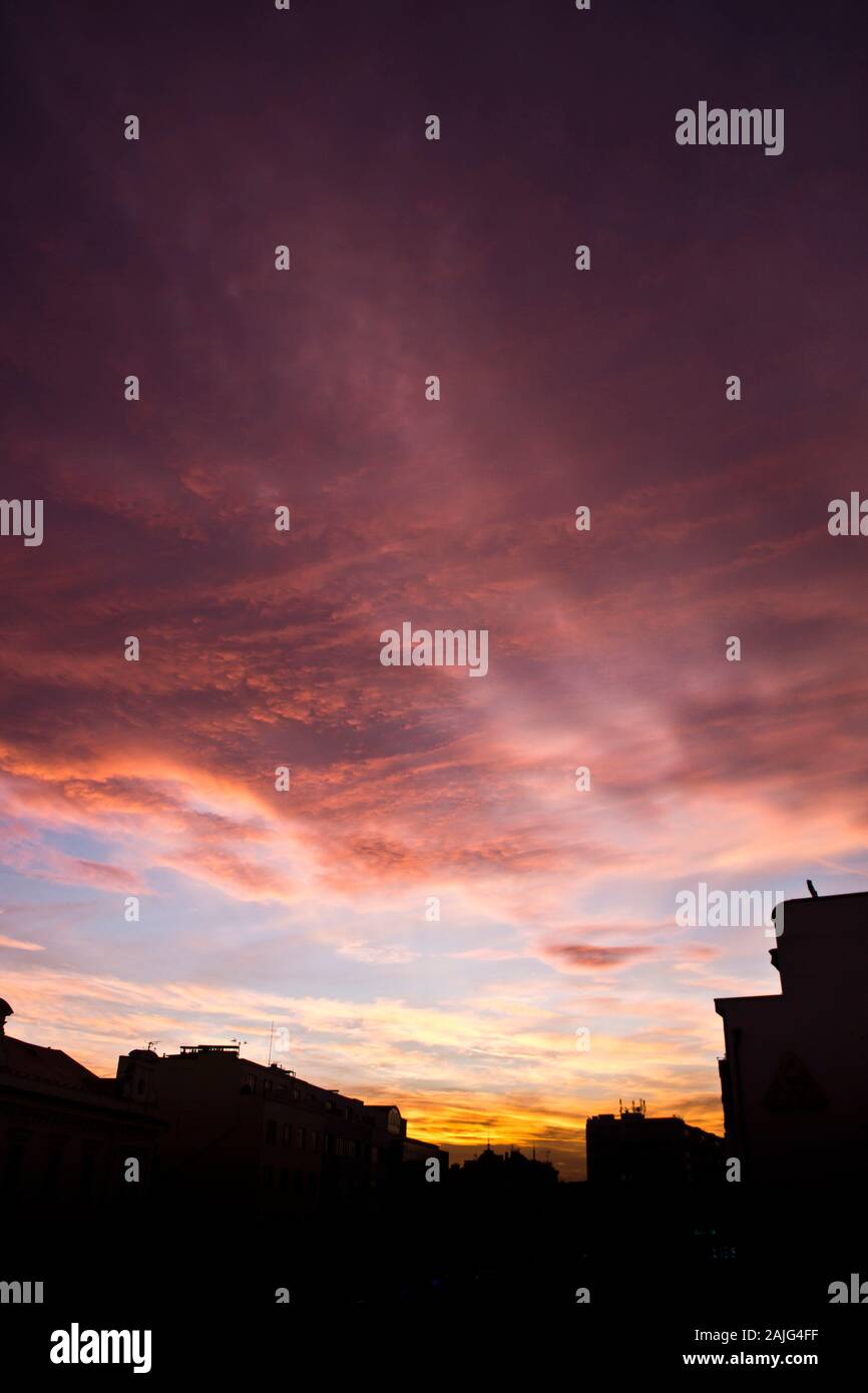 Rosso tramonto colorato con edifici in silhouette Foto Stock