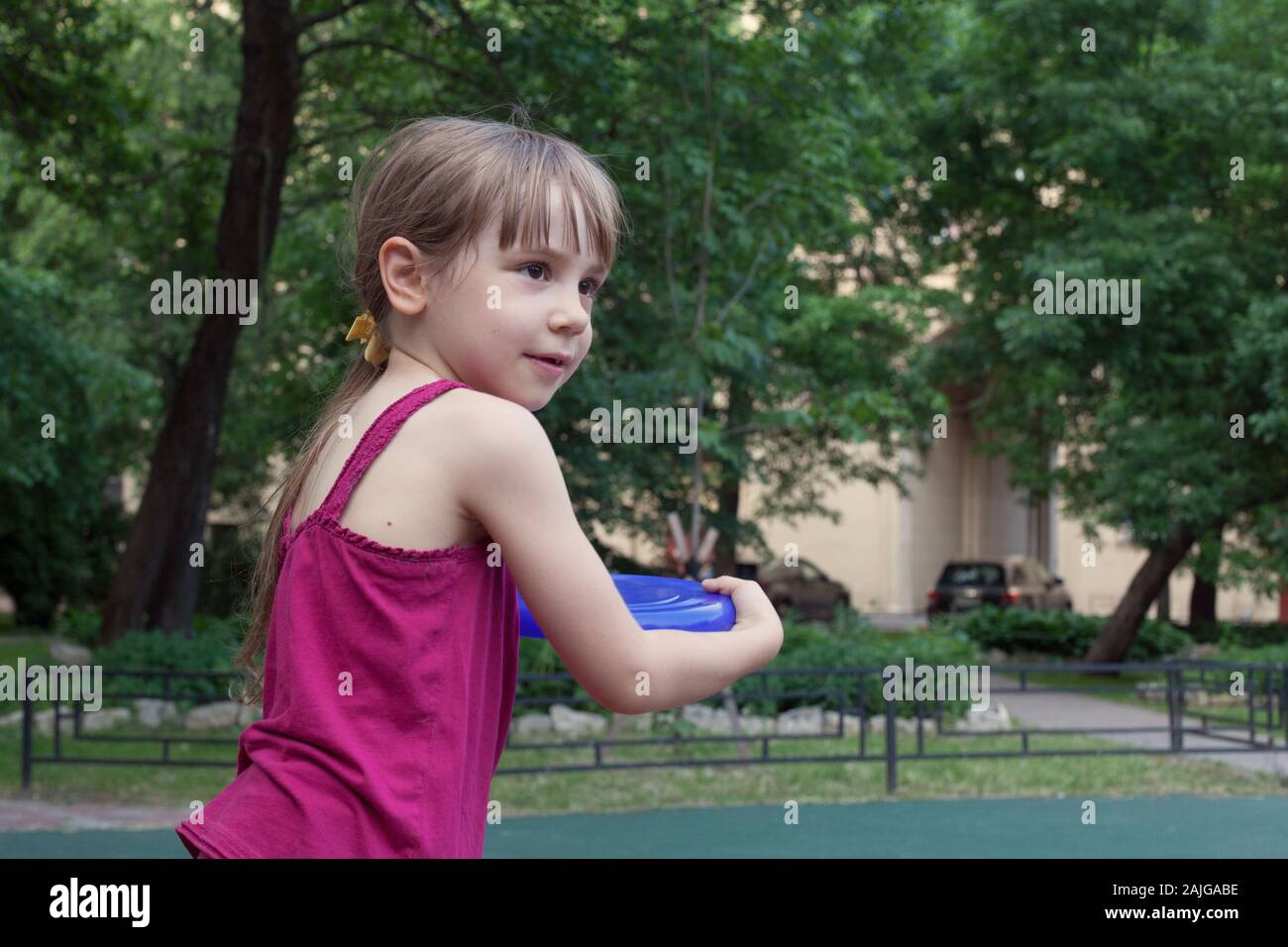 Ragazza giovane la riproduzione di una piastra di Frisbee in estate città giardino Foto Stock