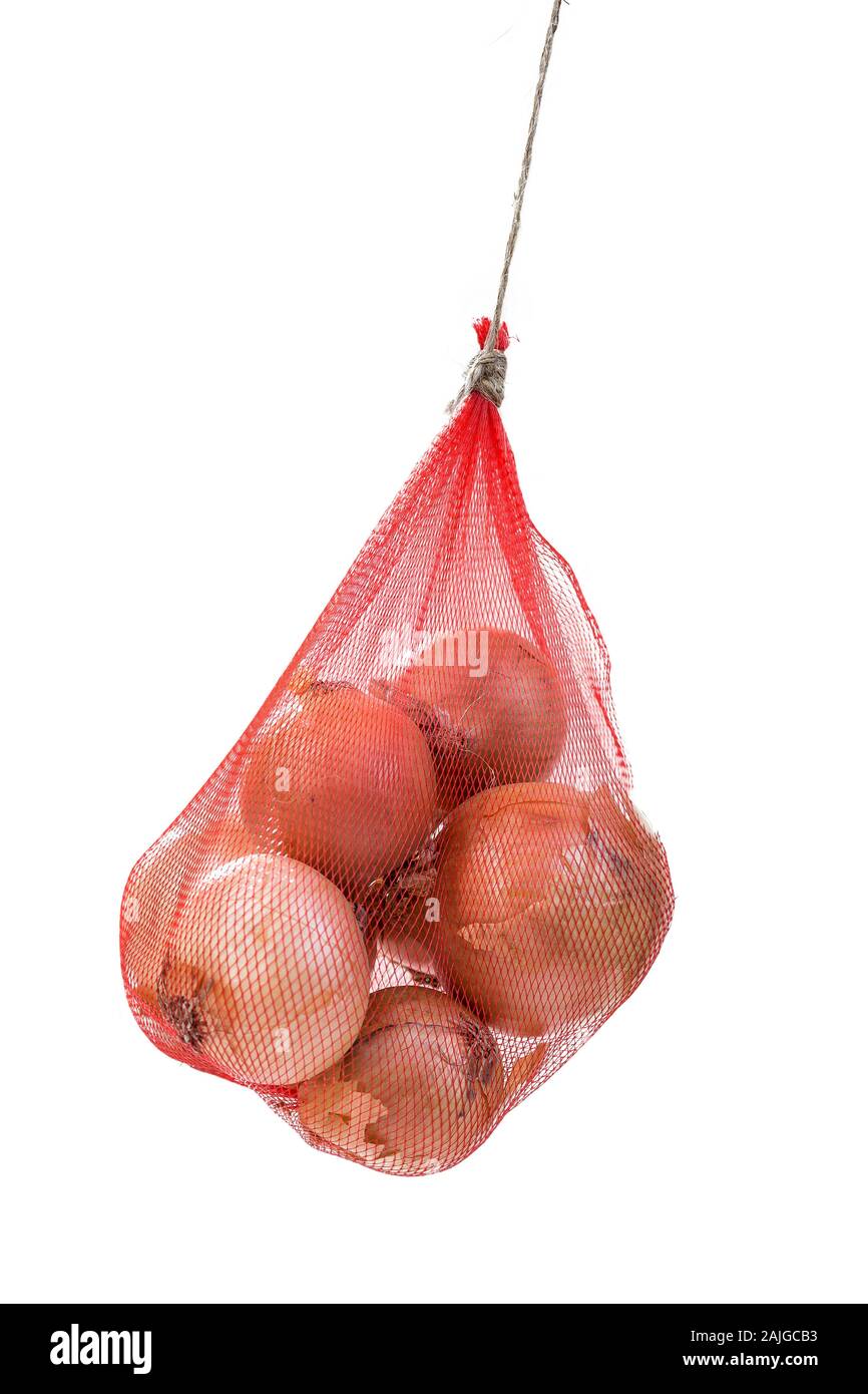 Rosolare la cipolla appeso imballate in un rosso borsa a rete su sfondo bianco Foto Stock