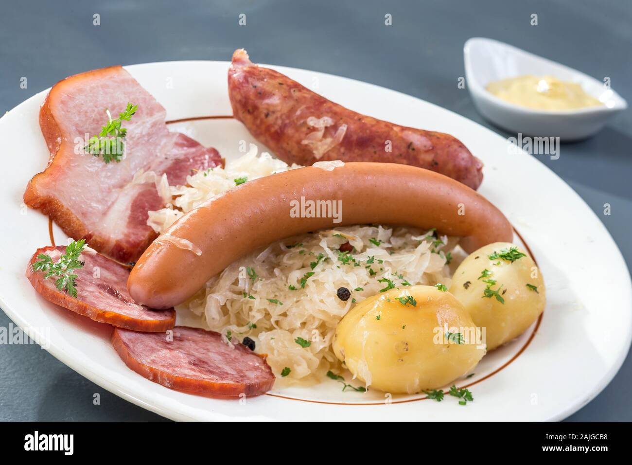 Choucroute garnie, una tipica piastra alsaziano, con salsicce, pancetta, crauti e patate Foto Stock