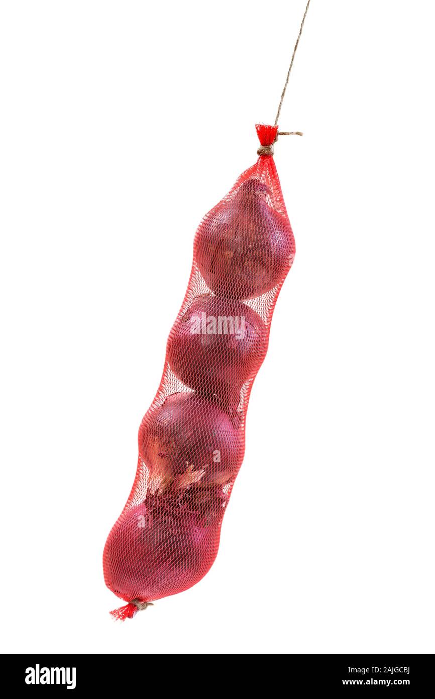 Cipolla rossa appeso imballate in un rosso borsa a rete su sfondo bianco Foto Stock