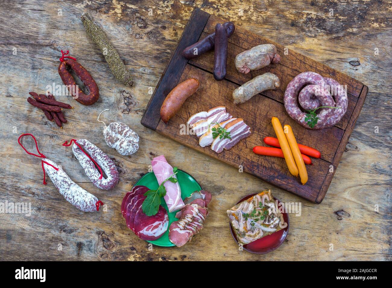 Selezione delle materie francese di salumi di bordo, con foglie di rucola e salsiccia secca su una tavola di legno backgroundi Foto Stock