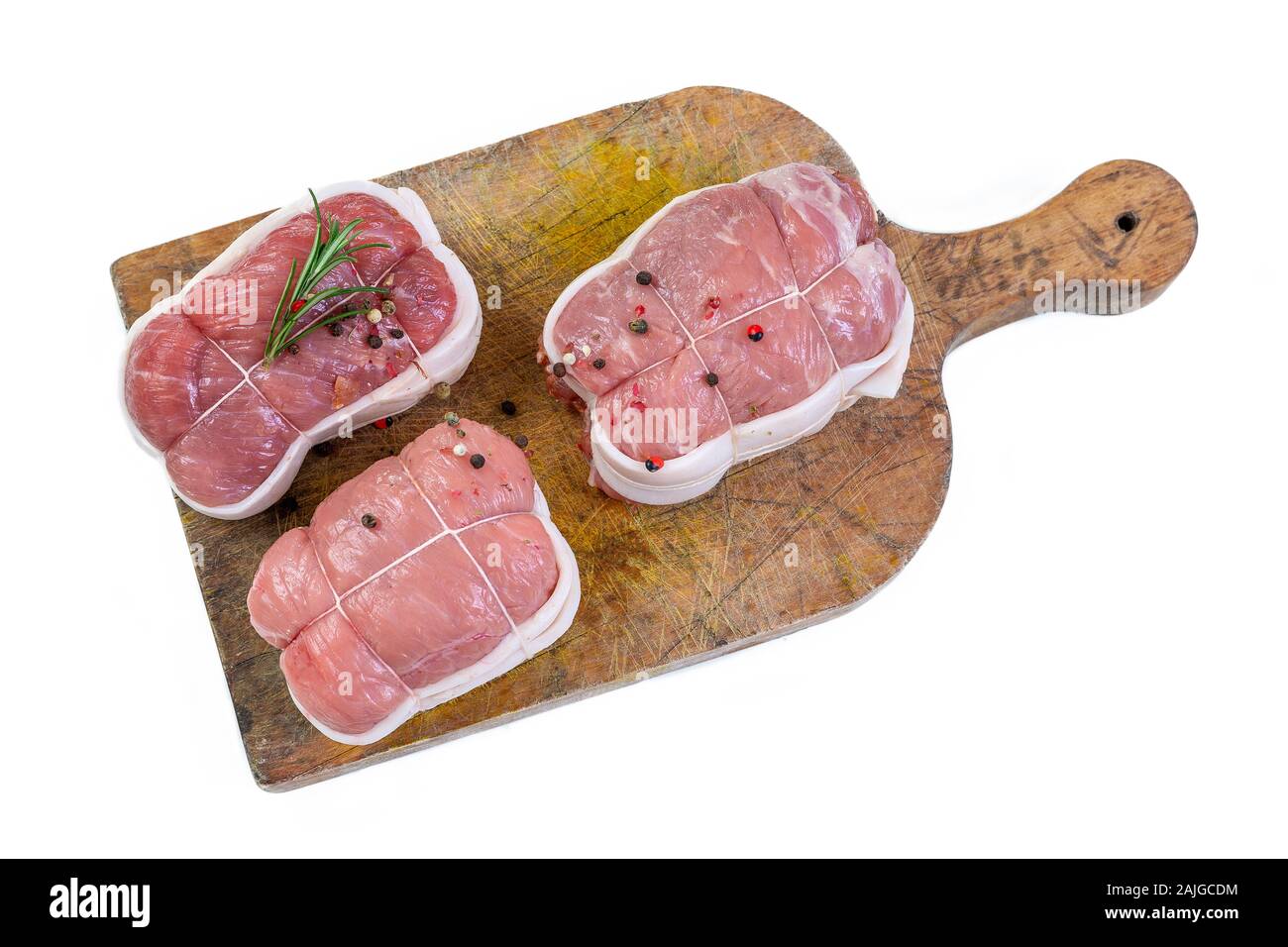 Carne cruda paupiettes, rosmarino e peppe rosso sul bord in legno e sfondo bianco Foto Stock