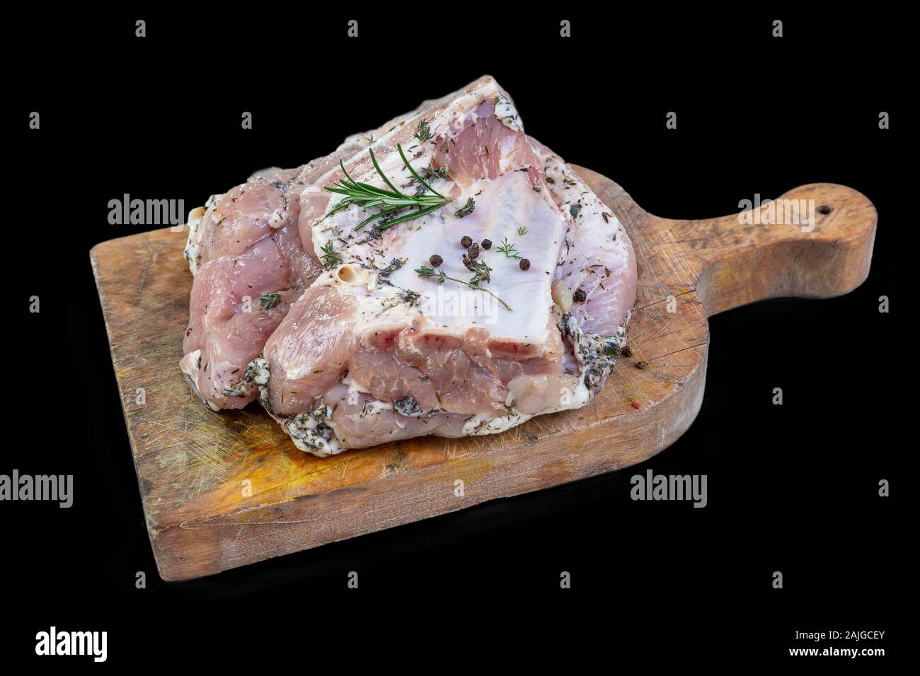Diversi pezzi di salati ventresche pancetta di maiale con la pelle sul tagliere su sfondo nero Foto Stock