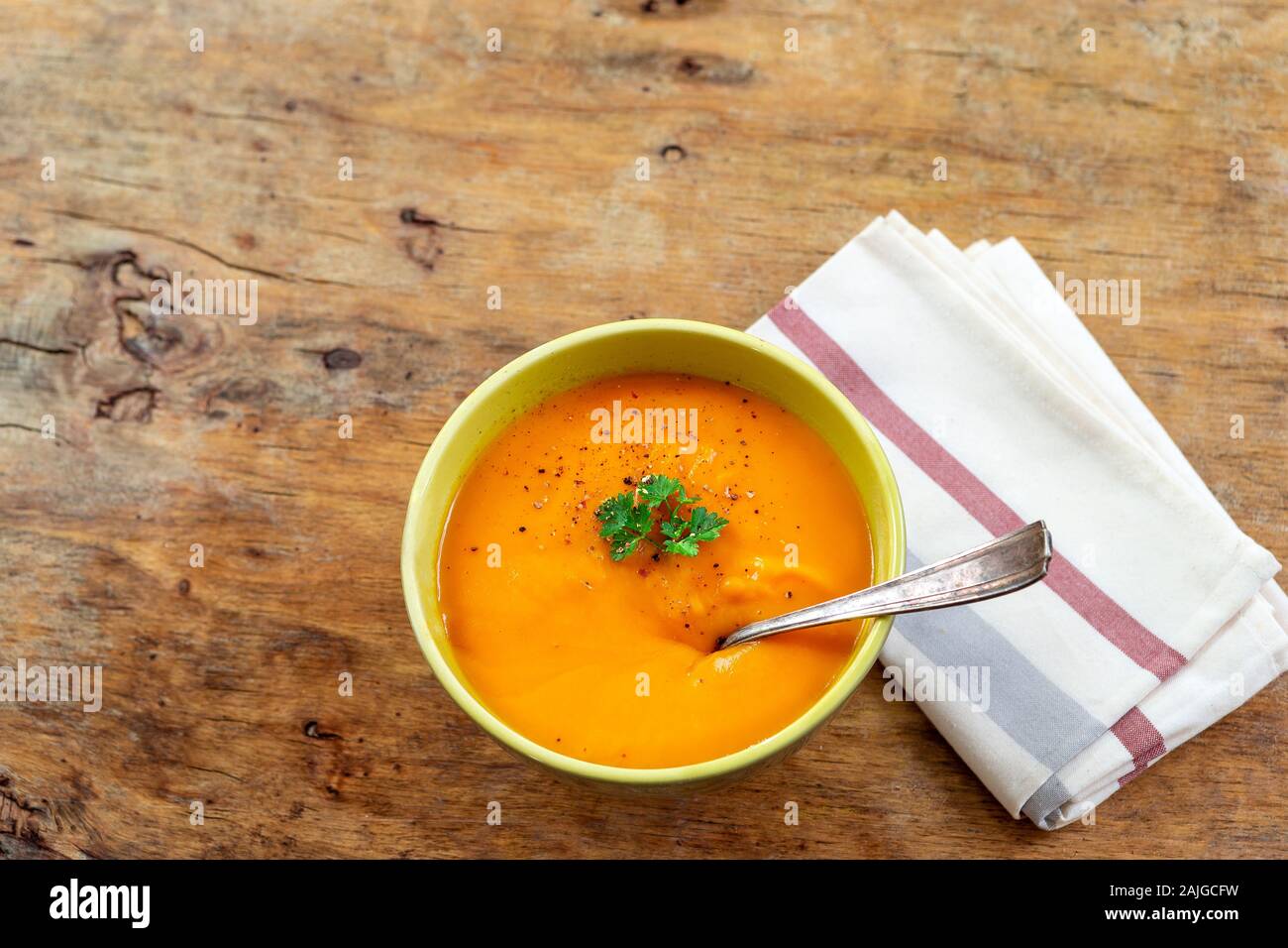 Salsa speziata zuppa di carote con crema e erbe fresche naturale vecchio tavolo in legno Foto Stock