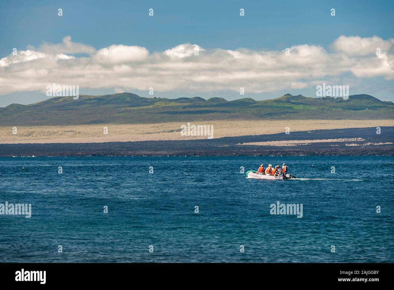 Isabela island e un gommone con turisti visto da isola Rabida nelle Galapagos, Ecuador. Foto Stock