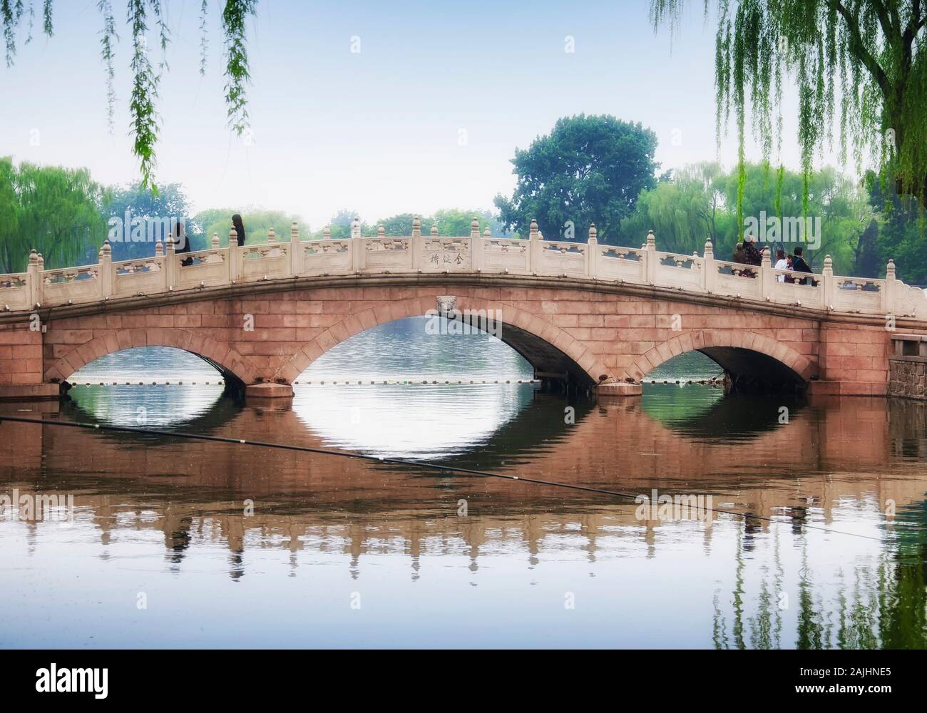 Pechino, Cina. Aprile 27, 2016. Jinding ponte sopra il lago Qianhai negli Hutong scenic area di Pechino Cina su un nuvoloso giorno. Foto Stock