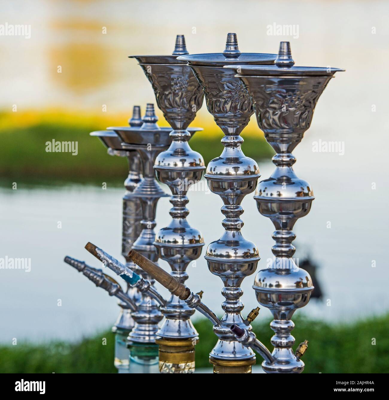 Metallo grande acqua shisha tubi in una fila con lo sfondo del fiume Foto Stock
