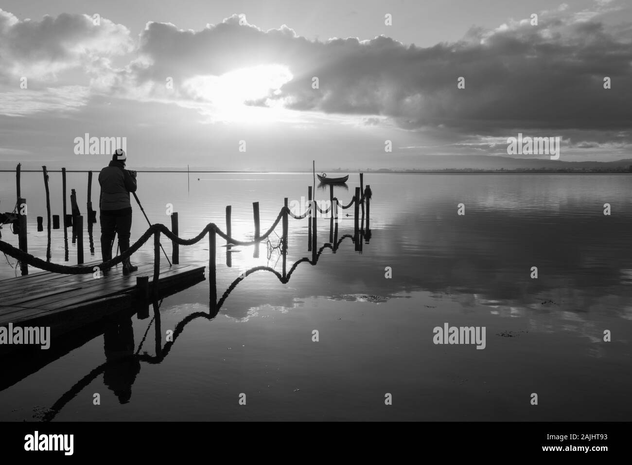 Fotografo che scatta la barca di legno all'alba Foto Stock