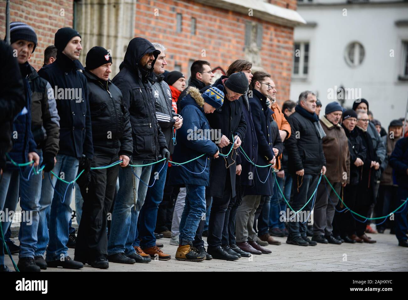 I partecipanti pregano durante il mensile uomini Rosario presso la Piazza Principale di Cracovia.poche decine di cattolico polacco gli uomini si riuniscono ogni primo sabato del mese per pregare e partecipare in una battaglia spirituale' chiedendo perdono per i casi di blasfemia. Foto Stock