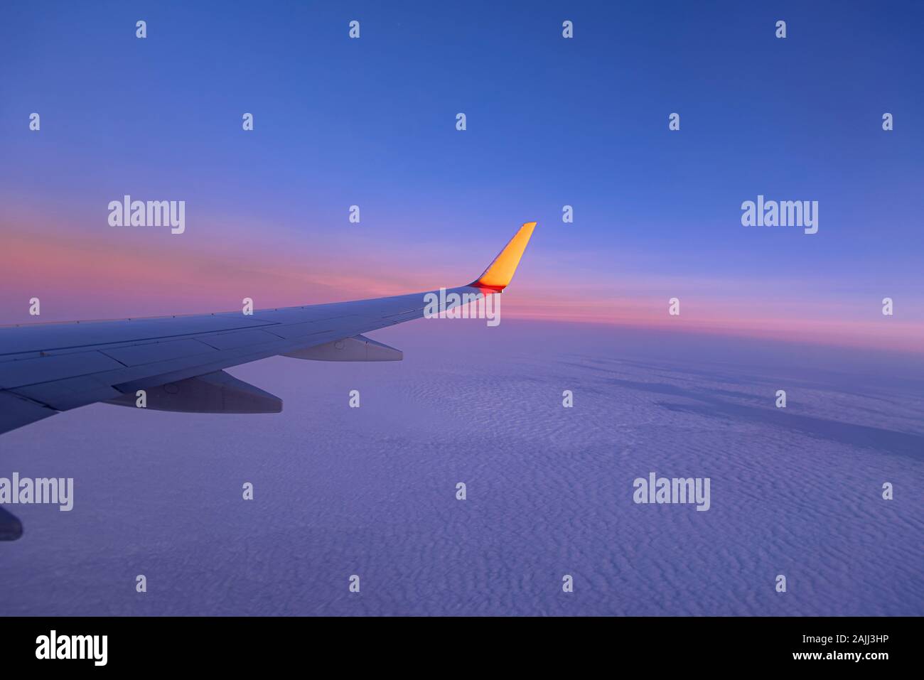 Tramonto su Sky e ala del piano, vista dalla finestra del velivolo, come sfondo Foto Stock