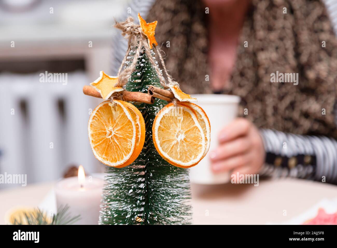 Essiccato arancione, stelle dal mandarino e cannella decorazione appeso a un albero di natale. sfondo sfocato. Foto Stock