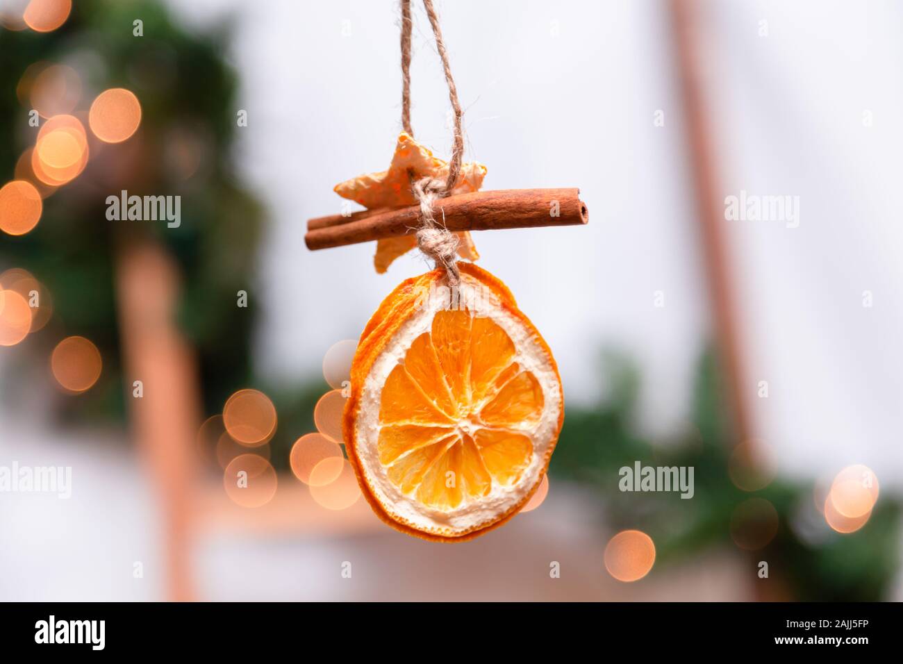 Appendere decorazione di Natale di arance essiccate, mandarino e cannella  stelle. Il concetto di vacanza. sfondo sfocato Foto stock - Alamy