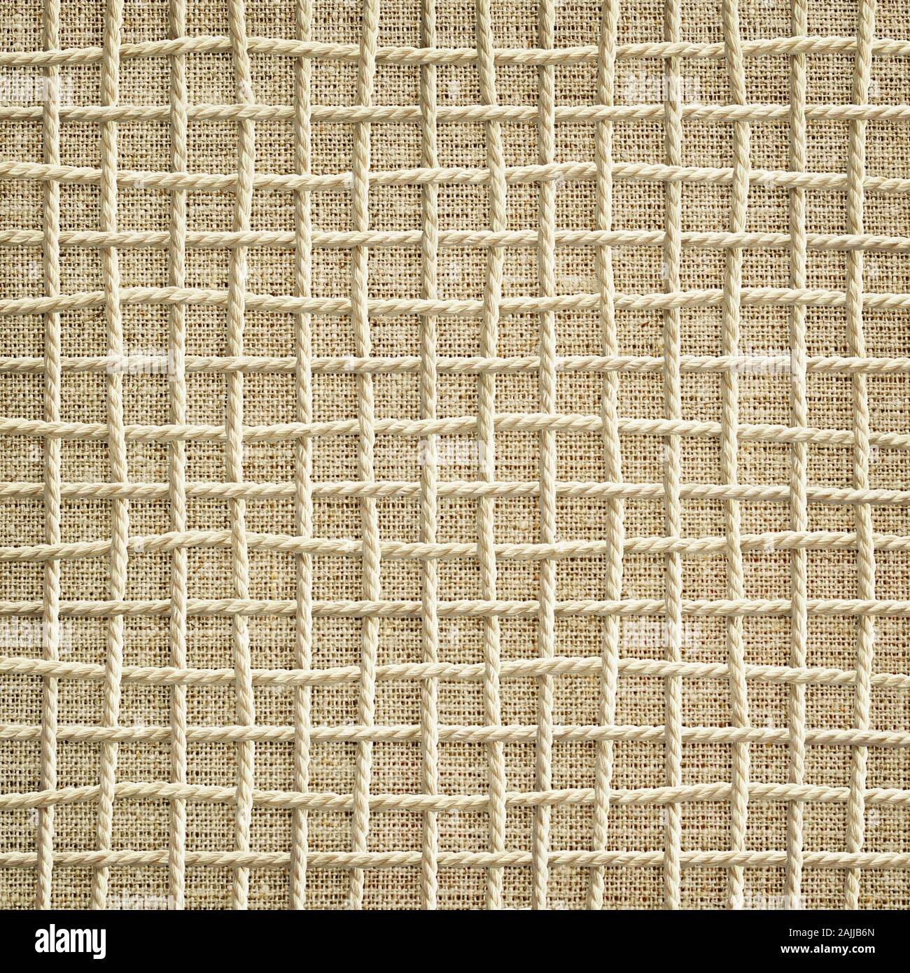 Sfondo di corda intrecciata nella forma di una griglia su tela Foto Stock
