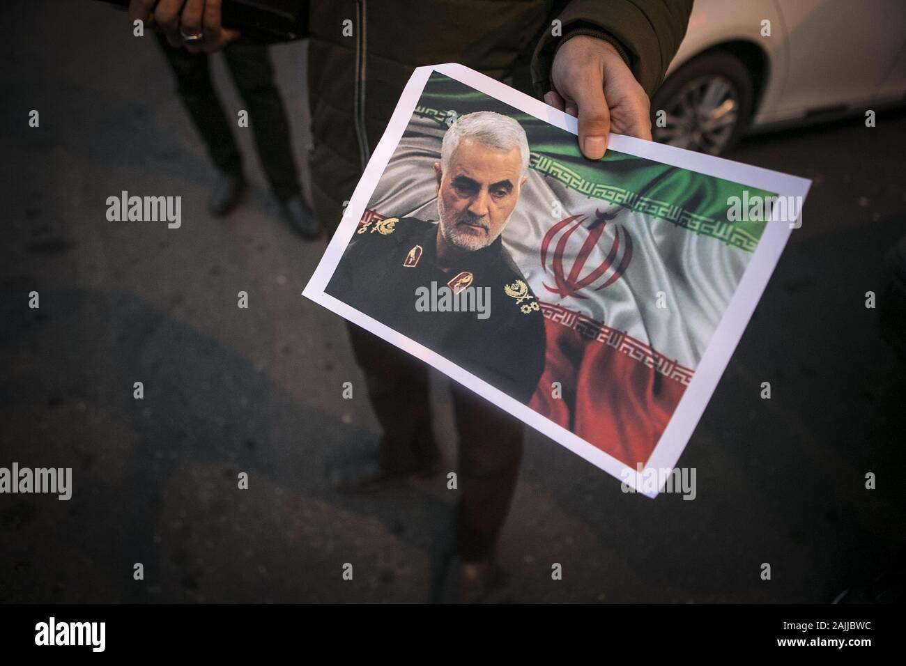 Pechino, Iran. 3 gennaio, 2020. Un uomo distribuisce un poster di alto profilo comandante iraniano Soleimani Qassem durante una manifestazione di protesta a Tehran, Iran, a gennaio 3, 2020. Credito: Ahmad Halabisaz/Xinhua/Alamy Live News Foto Stock