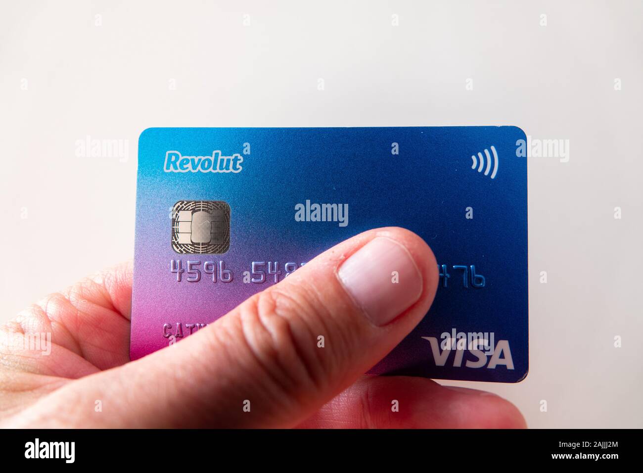 Mans pollice e mano con carta di credito Revolut Visa Foto stock - Alamy