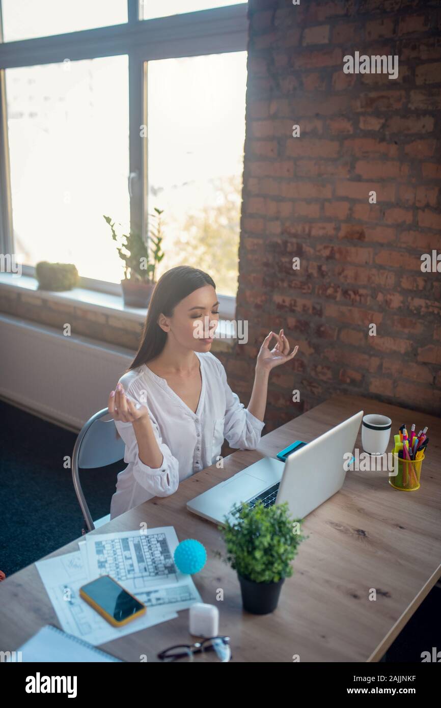 Attraente giovane donna avente un minuto per rilassarsi Foto Stock