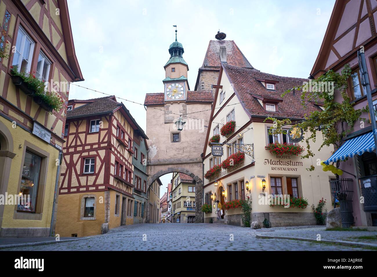 Edifici medievali e porta torre dell'orologio alle mura che circondano la città vecchia di Rothenburg, Germania Foto Stock