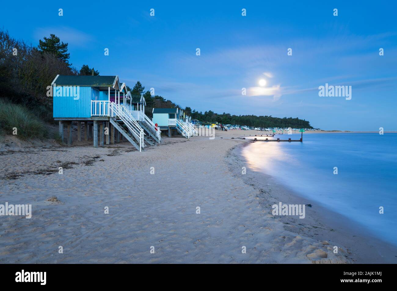 Luna piena sopra la spiaggia di capanne di pozzetti accanto il mare spiaggia, Pozzi-next-il-Mare, Norfolk, Inghilterra, Regno Unito, Europa Foto Stock