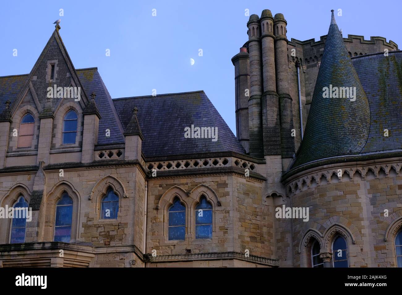 Aberystwyth Ceredigion Wales UK gennaio 04 2020: Moon Rising oltre l'architettura gotica di Aberystwyth University Foto Stock